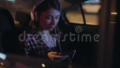 女乘客在车里用立体声耳机听音乐